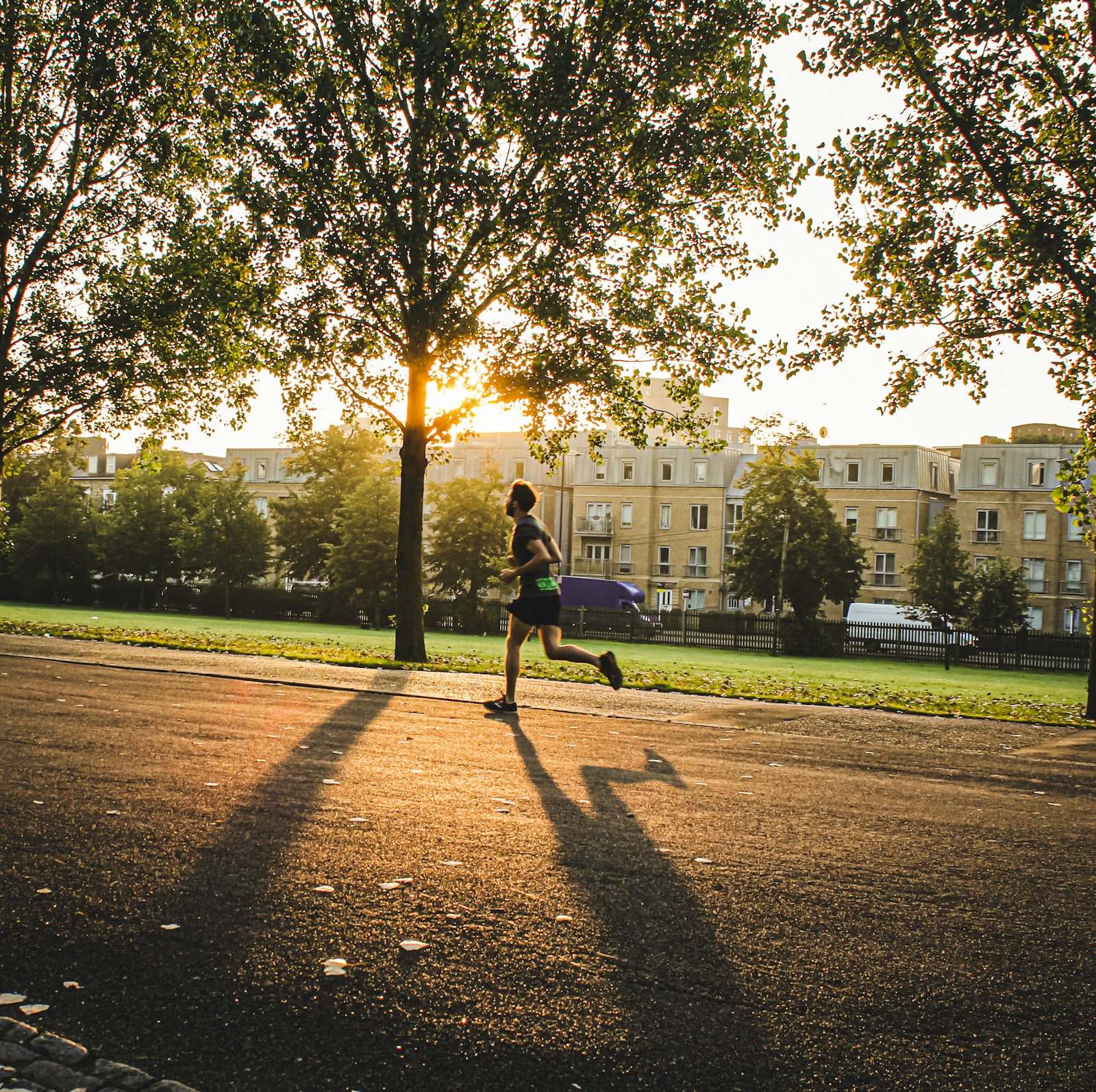 Runner moving down a sunlit street.